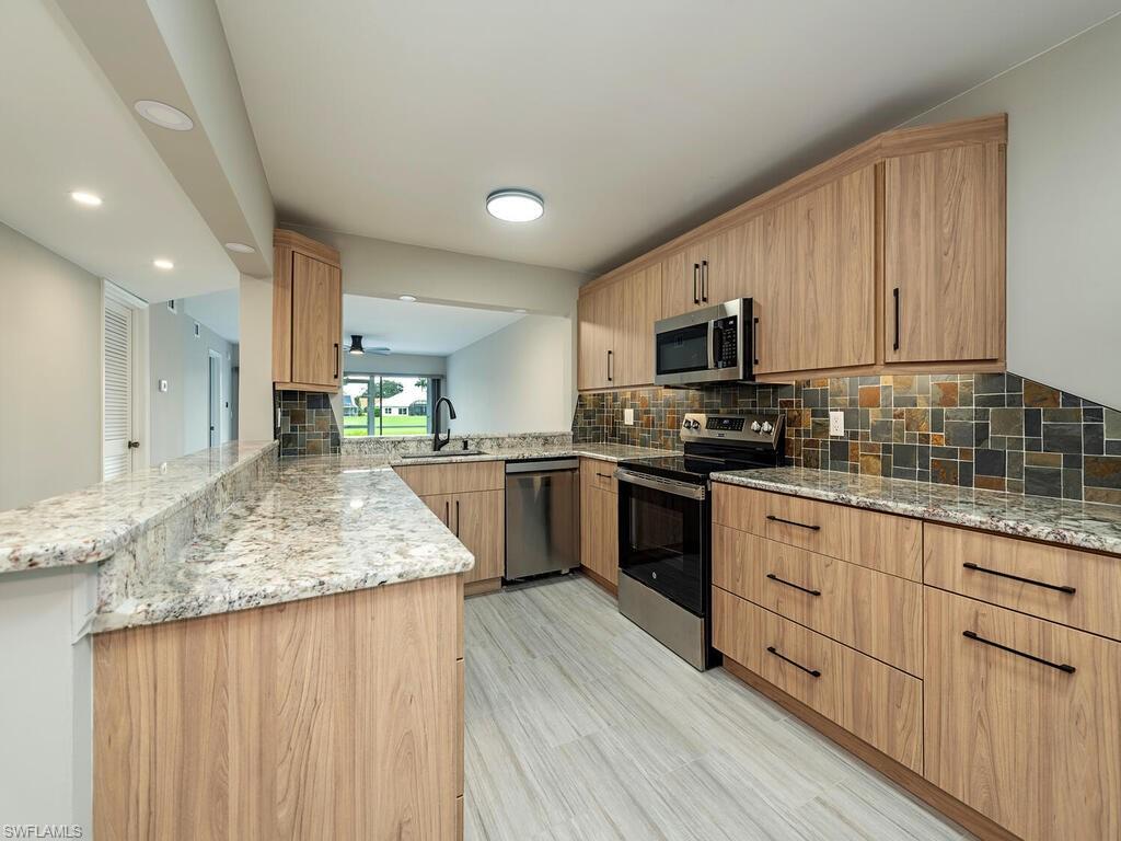 760 Augusta Boulevard, Unit D101 Naples, FL 34113 - Photo 2 of 13 a kitchen with granite countertop sink stove and cabinets