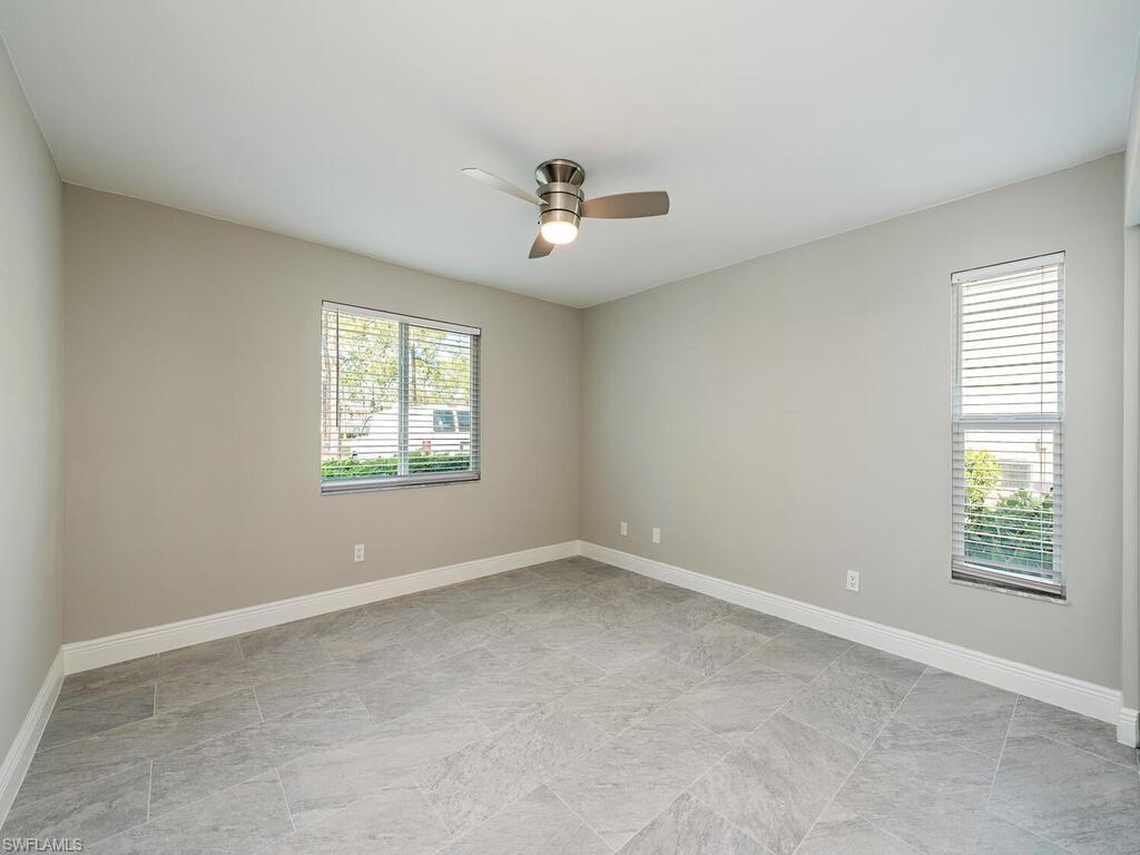 760 Augusta Boulevard, Unit D101 Naples, FL 34113 - Photo 9 of 13 an empty room with windows and ceiling fan