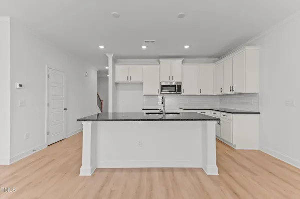 a large kitchen with stainless steel appliances granite countertop a sink and cabinets