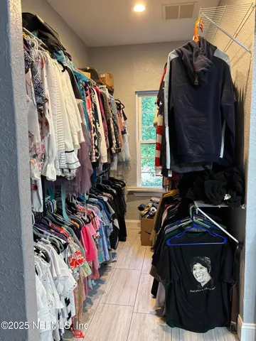 a view of walk in closet with clothes and shoes