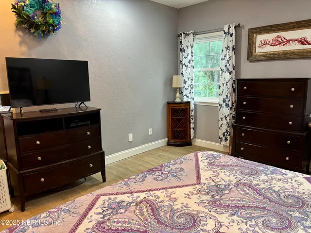 a bedroom with a bed and a flat screen television