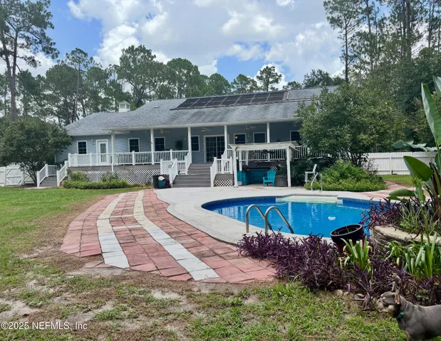 an aerial view of a house with swimming pool and yard
