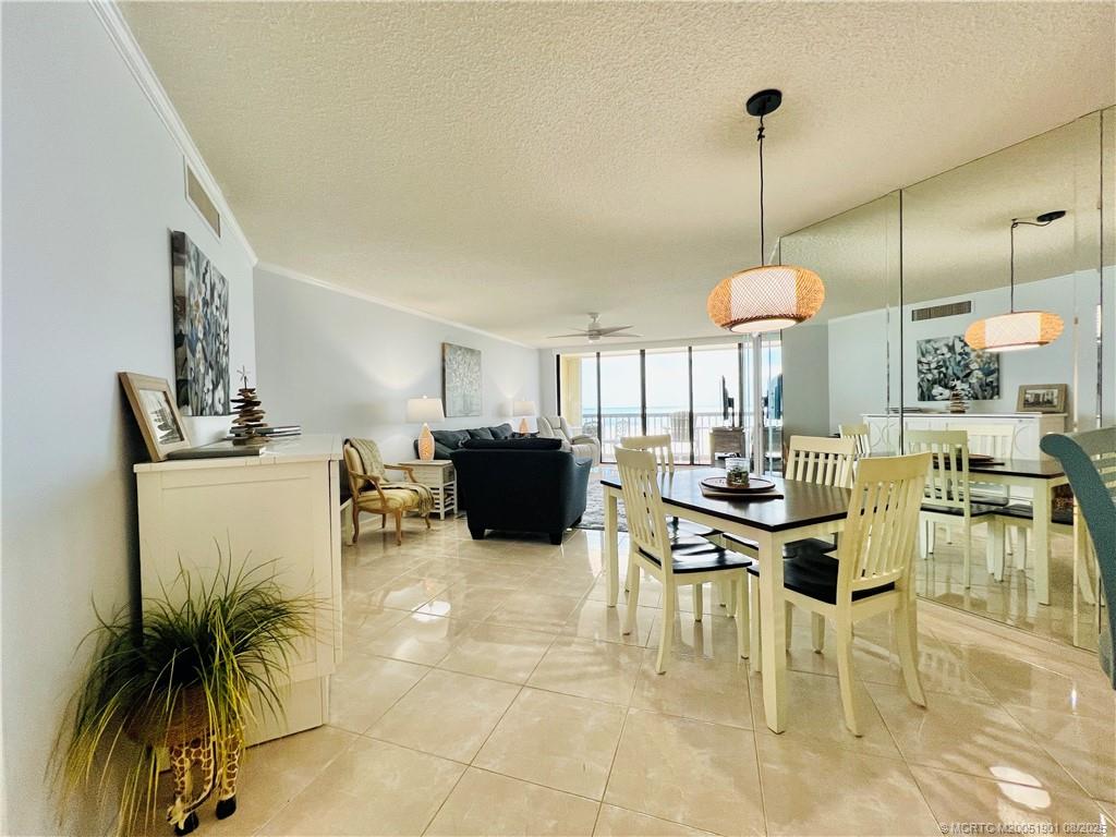 9500 South Ocean Drive, Unit 809 Jensen Beach, FL 34957 - Photo 14 of 64 a view of a dining room and livingroom with furniture wooden floor a chandelier