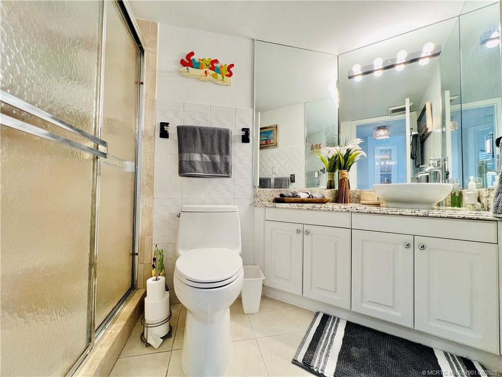 9500 South Ocean Drive, Unit 809 Jensen Beach, FL 34957 - Photo 17 of 64 a bathroom with a granite countertop sink toilet and shower