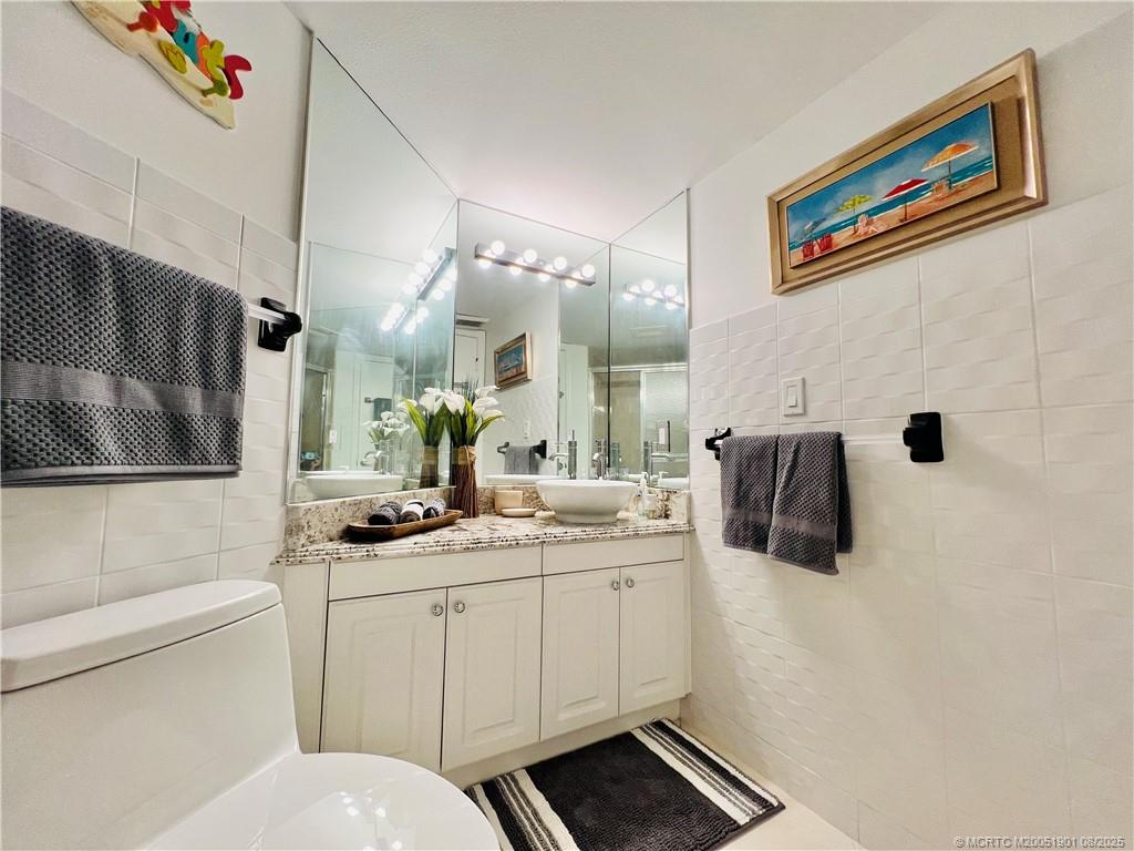 9500 South Ocean Drive, Unit 809 Jensen Beach, FL 34957 - Photo 18 of 64 a bathroom with a sink a toilet a mirror and shower