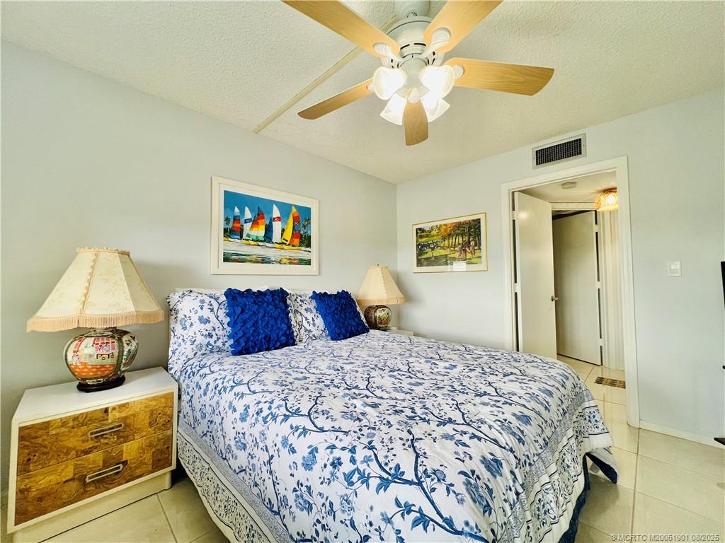 9500 South Ocean Drive, Unit 809 Jensen Beach, FL 34957 - Photo 23 of 64 a bedroom with a large bed and a chandelier