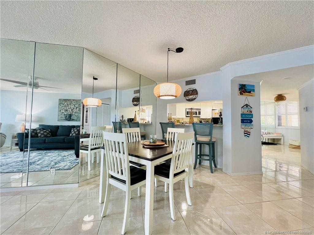 9500 South Ocean Drive, Unit 809 Jensen Beach, FL 34957 - Photo 28 of 64 a kitchen with stainless steel appliances kitchen island granite countertop a table and chairs in it