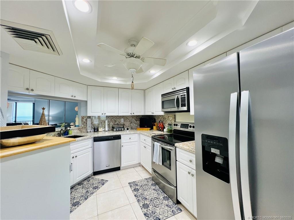 9500 South Ocean Drive, Unit 809 Jensen Beach, FL 34957 - Photo 8 of 64 a kitchen with a sink a counter top space stainless steel appliances and cabinets