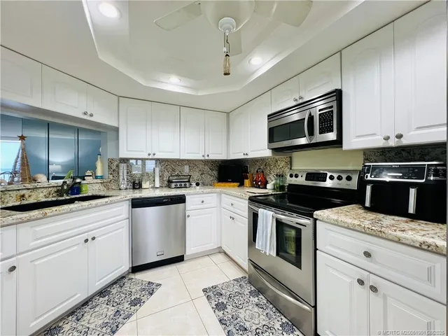 a kitchen with stainless steel appliances granite countertop a refrigerator and a sink