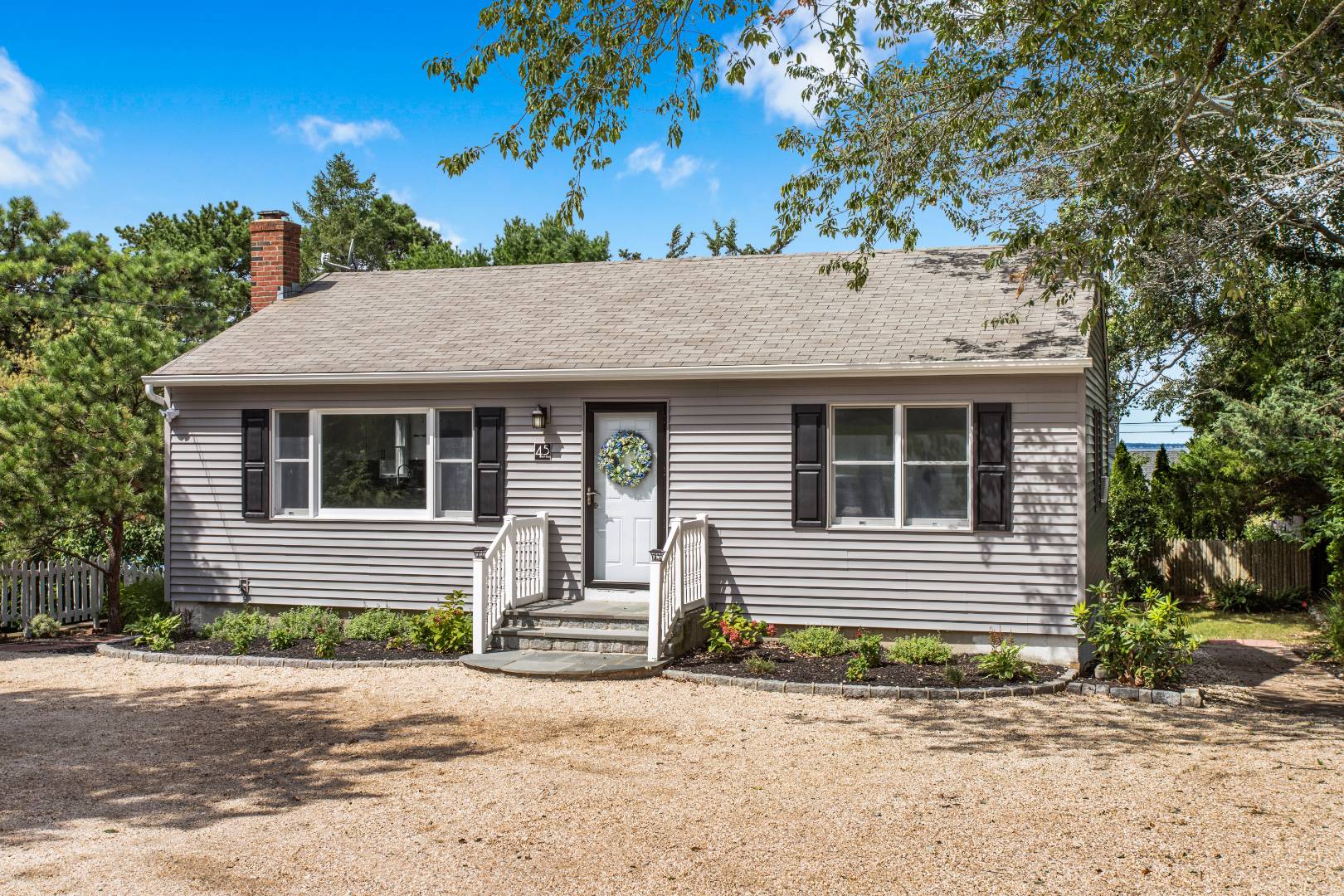 45 North Road Hampton Bays, NY 11946 - Photo 2 of 14 a front view of a house with a garden