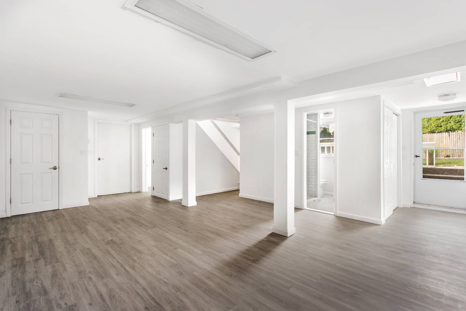 45 North Road Hampton Bays, NY 11946 - Photo 11 of 14 an empty room with wooden floor & windows and bathroom