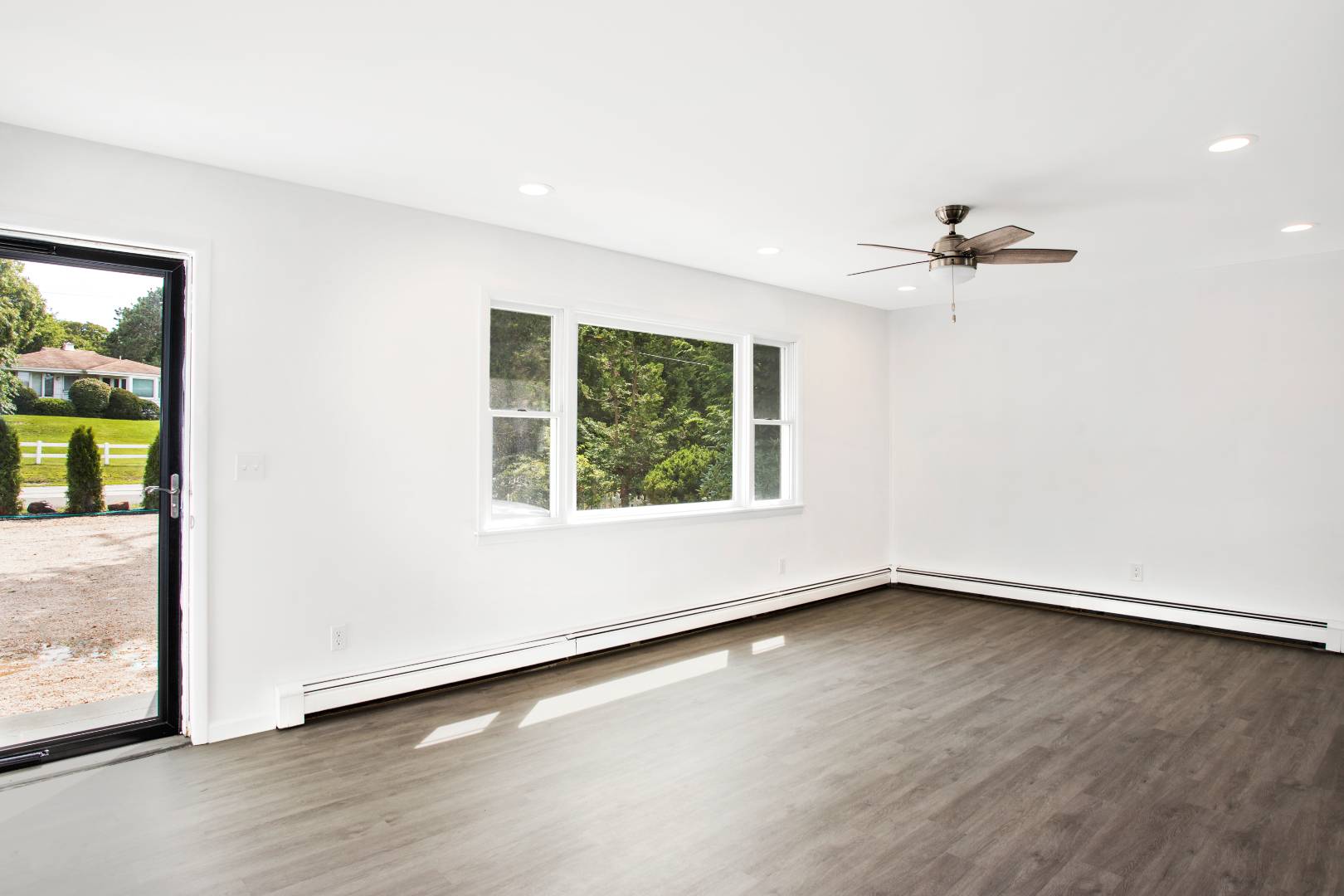 45 North Road Hampton Bays, NY 11946 - Photo 4 of 14 an empty room with wooden floor and windows