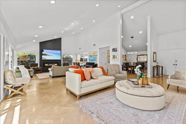 a living room with fireplace furniture and a view of kitchen