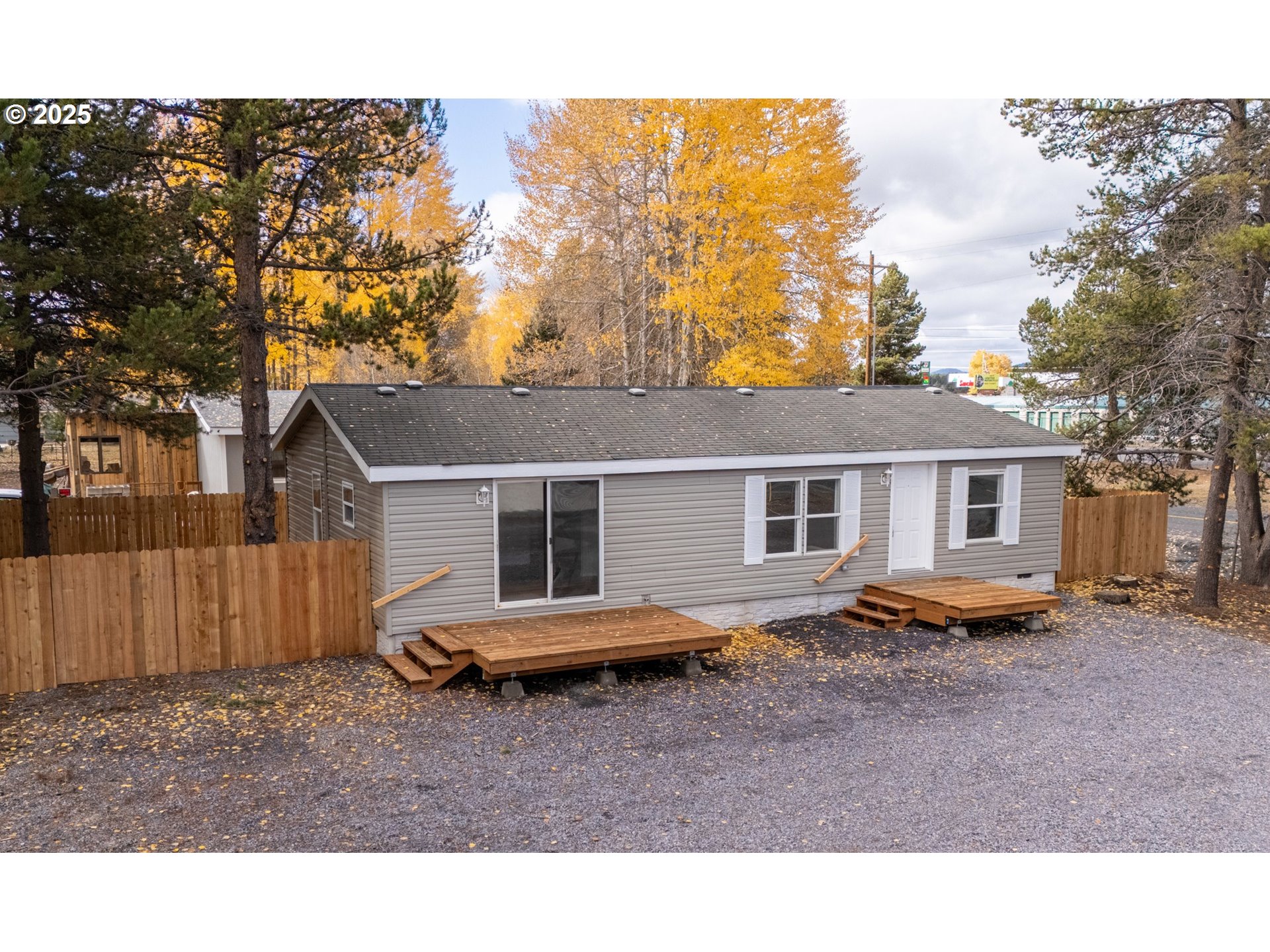 a backyard of a house with barbeque oven stove and large tree