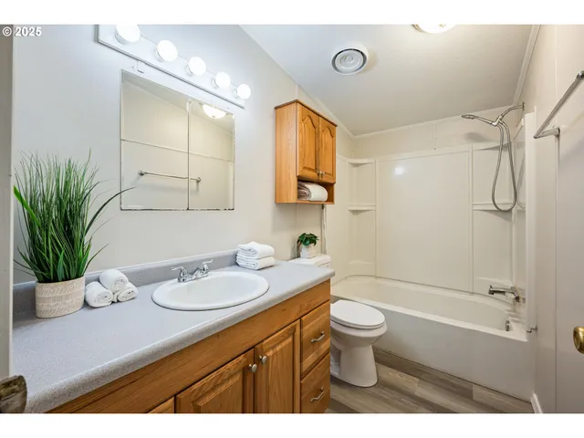 a bathroom with a granite countertop sink a toilet and shower
