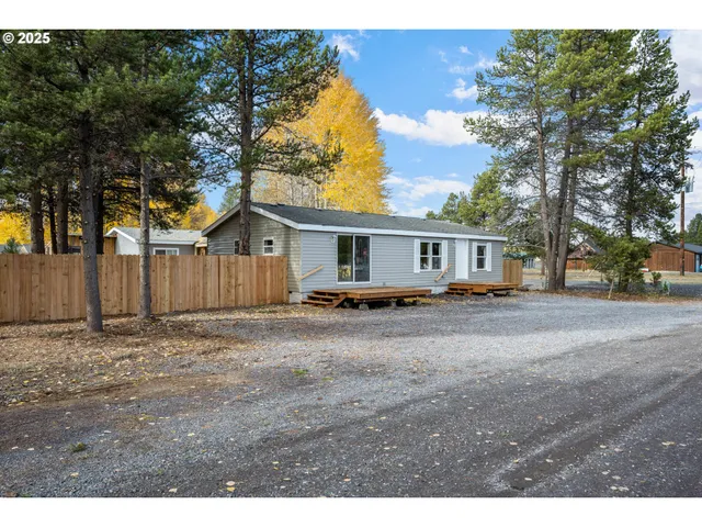 a view of a house with backyard and a tree