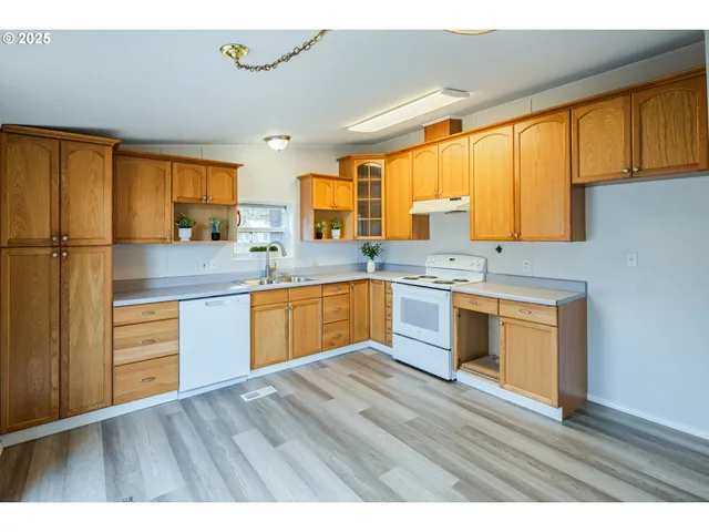 a kitchen with stainless steel appliances granite countertop a stove a sink dishwasher and a refrigerator