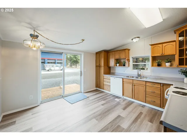 a open kitchen with granite countertop a sink window and refrigerator