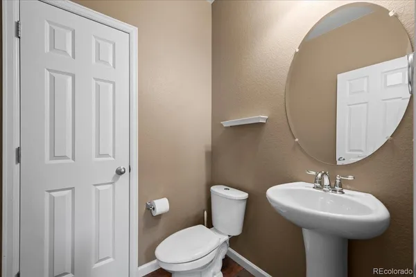 a bathroom with a toilet sink and mirror