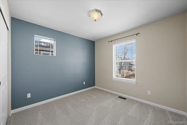 an empty room with windows and closet