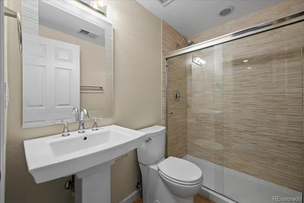 a bathroom with a sink a toilet and shower