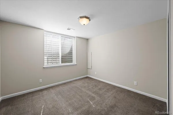an empty room with a window and a ceiling fan
