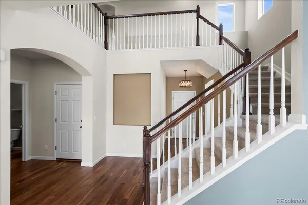 a view of staircase with railing and white walls
