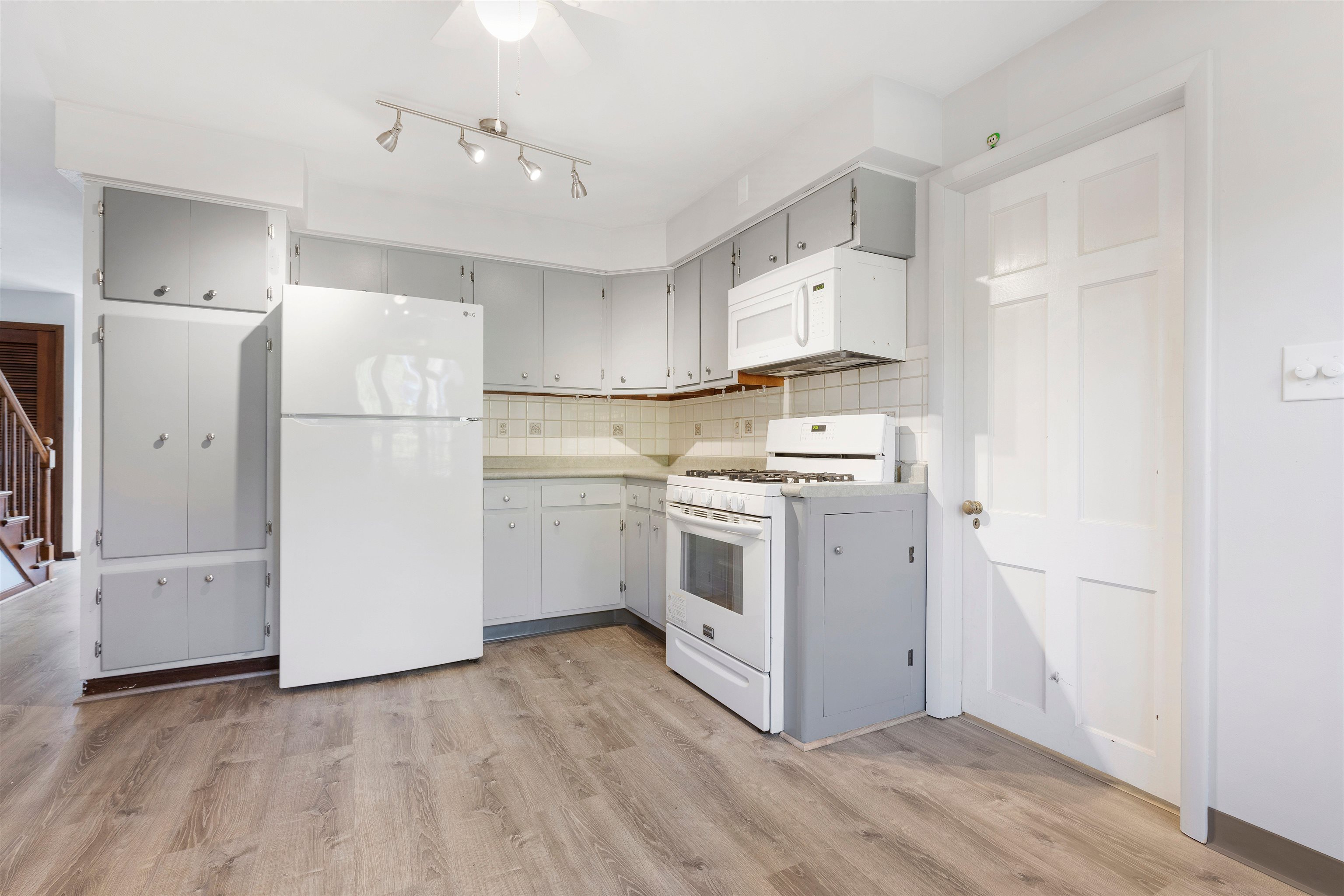 4962 Braewild Road Rockford, IL 61107 - Photo 5 of 20 a kitchen with white cabinets and white appliances