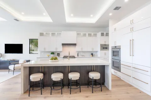 a kitchen with a dining table chairs and white appliances