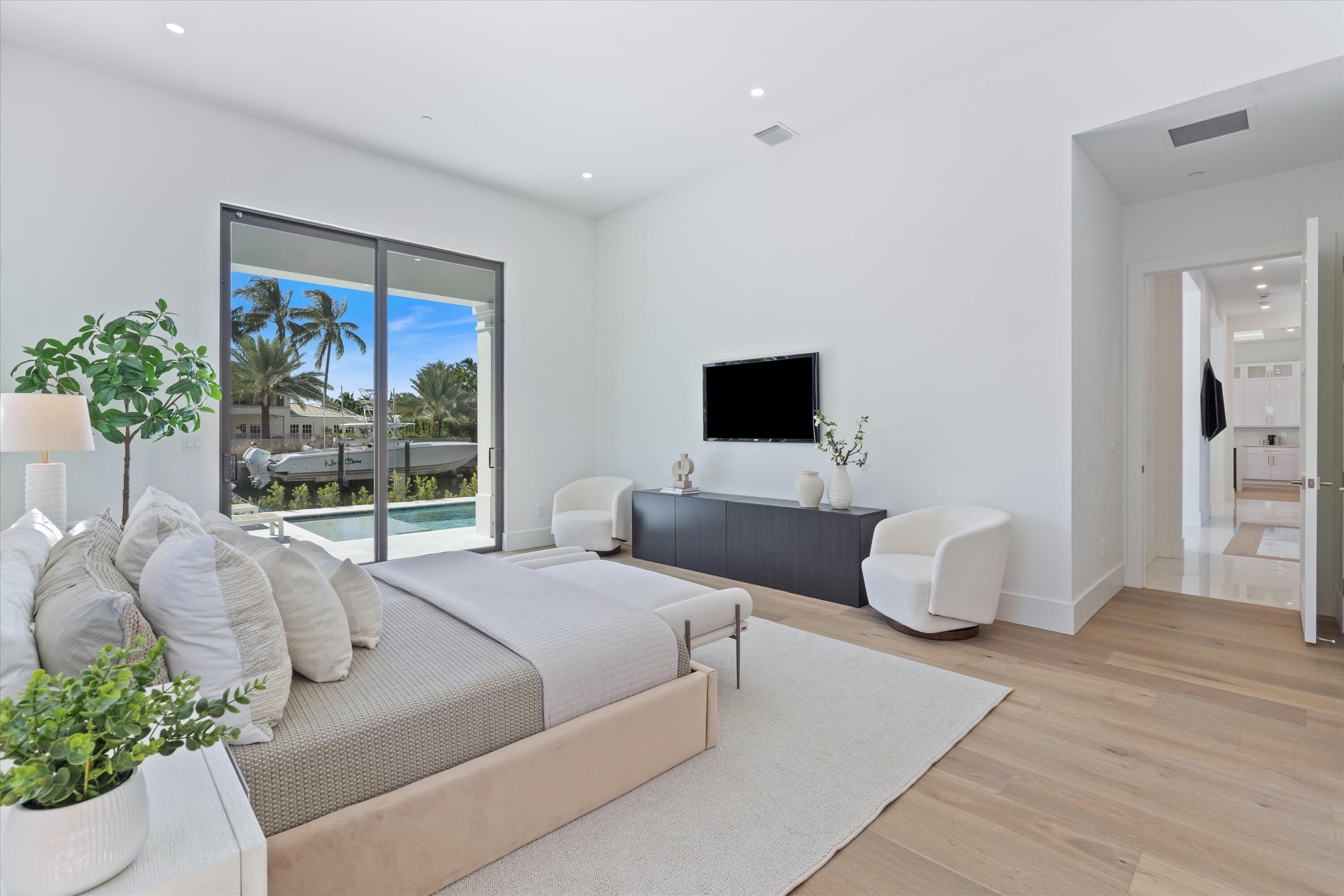 1211 Gulfstream Way Singer Island, FL 33404 - Photo 19 of 54 a bedroom with a bed and glass window