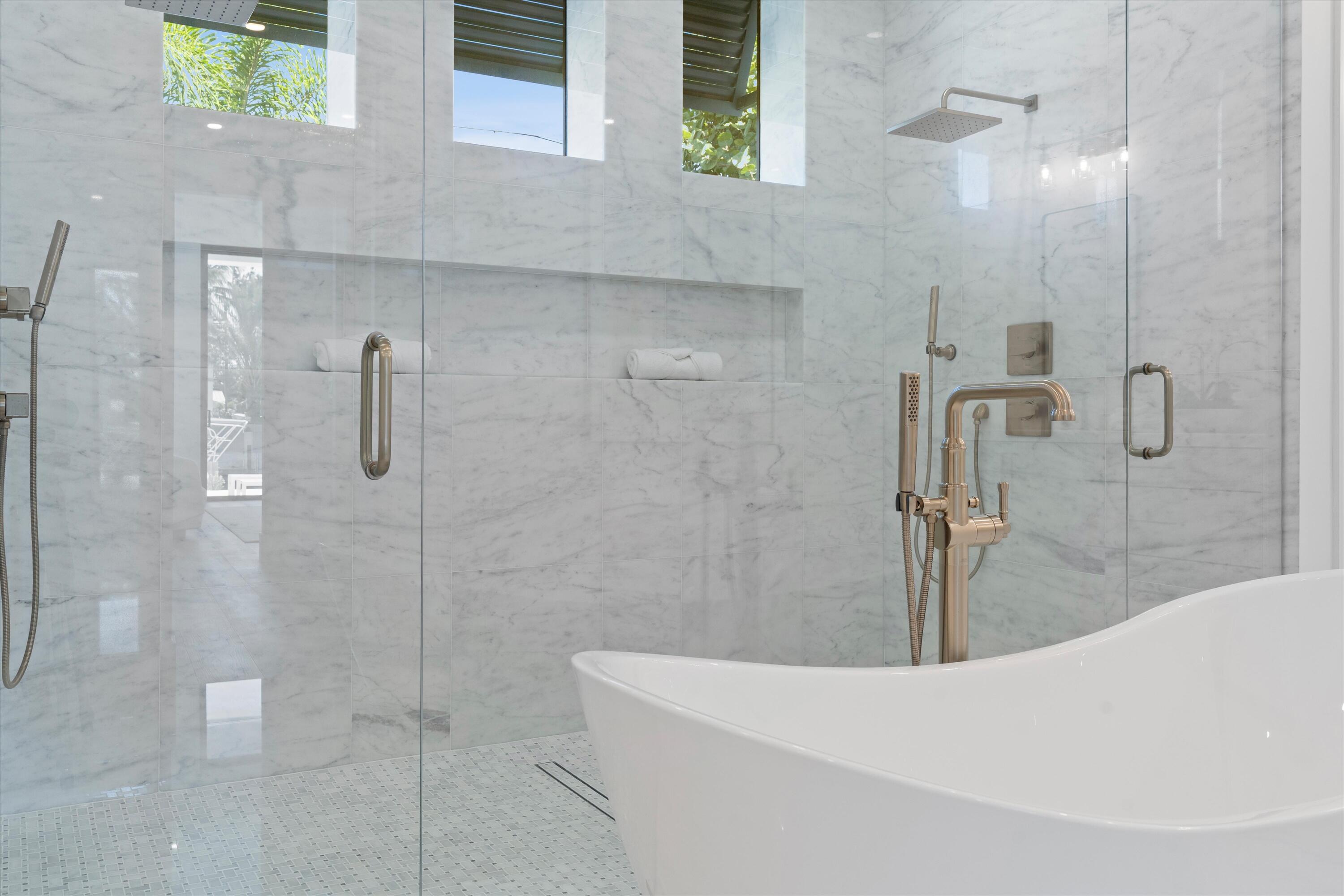 1211 Gulfstream Way Singer Island, FL 33404 - Photo 26 of 54 a bathroom with a tub a window and glass door