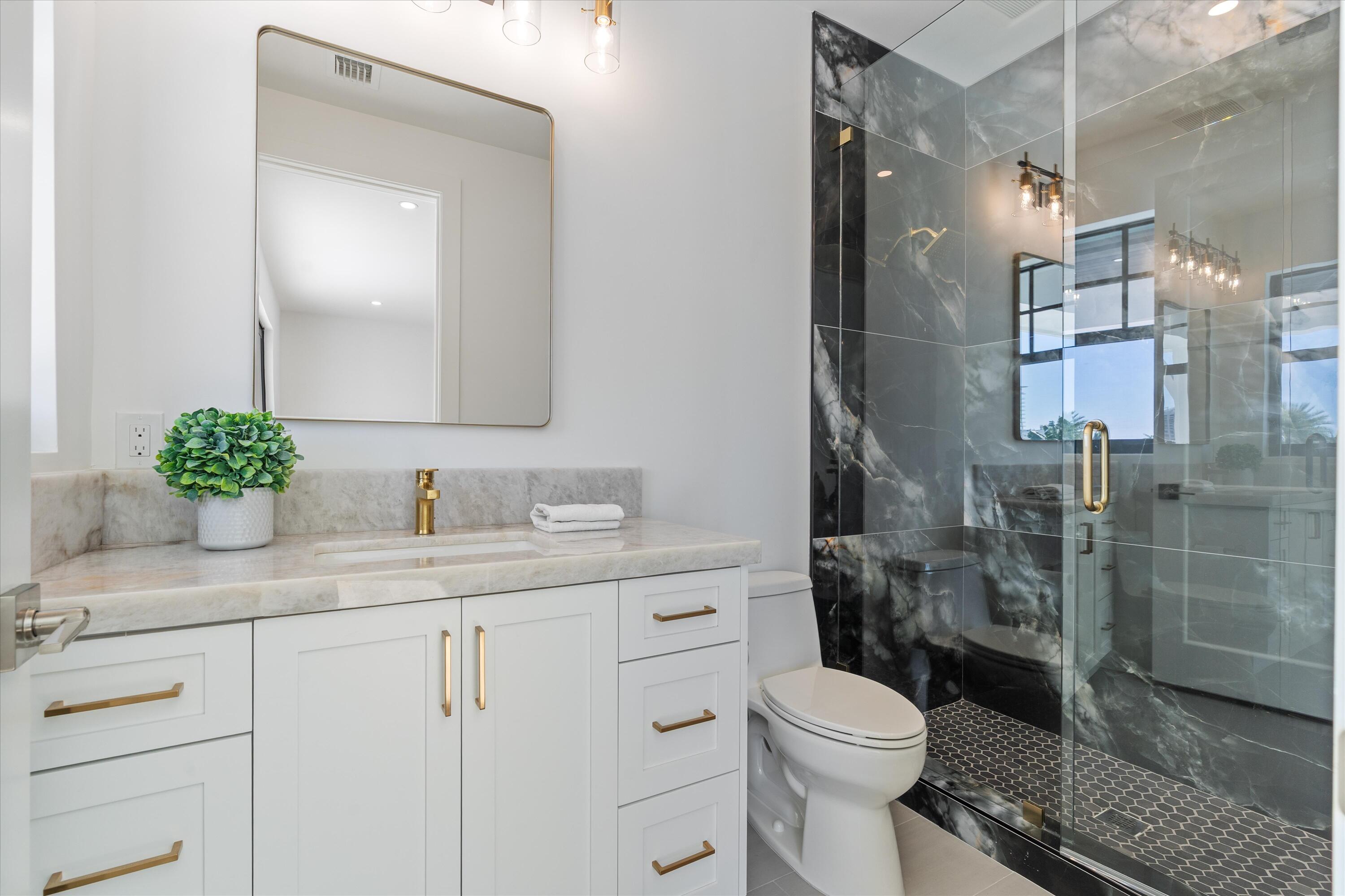 1211 Gulfstream Way Singer Island, FL 33404 - Photo 31 of 54 a bathroom with a sink a toilet and shower