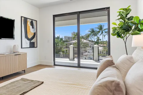 a bedroom with a large bed and a potted plant