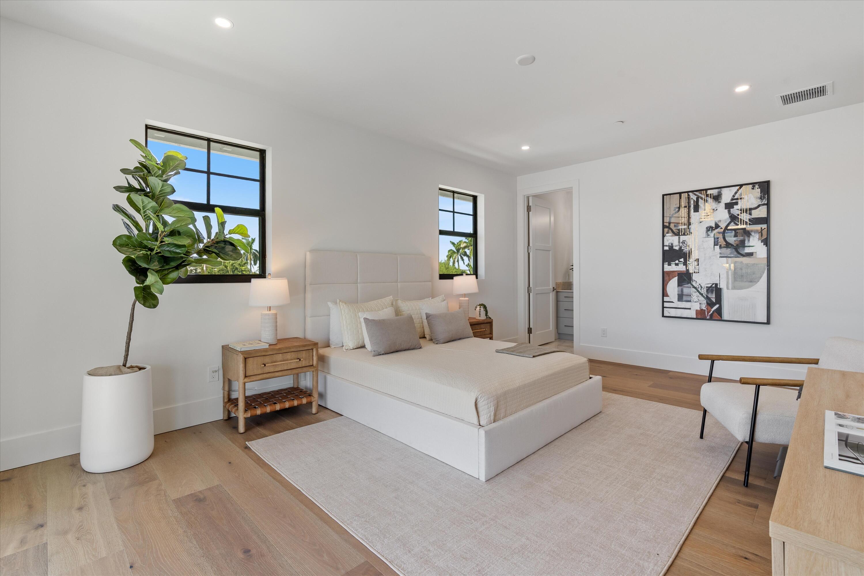 1211 Gulfstream Way Singer Island, FL 33404 - Photo 35 of 54 a bedroom with a large bed and a potted plant