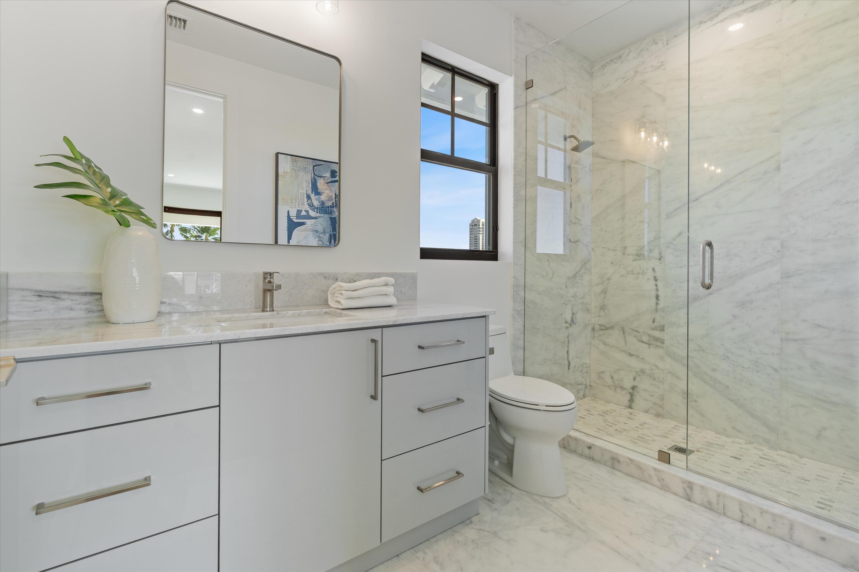 1211 Gulfstream Way Singer Island, FL 33404 - Photo 37 of 54 a bathroom with a double vanity sink toilet and shower