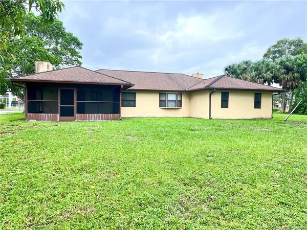 a front view of a house with yard and trees