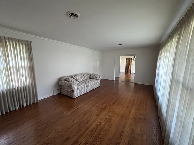 a spacious bedroom with a bed and wooden floor