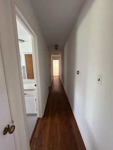 a view of a hallway with wooden floor and staircase