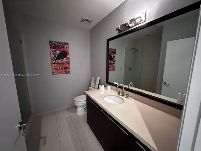 a bathroom with a sink a toilet a mirror and vanity