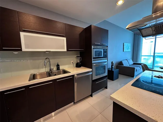 a kitchen with stainless steel appliances a sink dishwasher stove refrigerator and cabinets