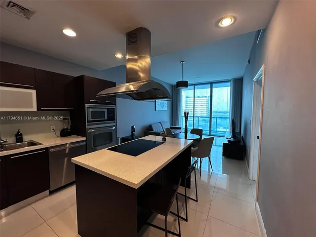 a kitchen with a table chairs refrigerator and cabinets