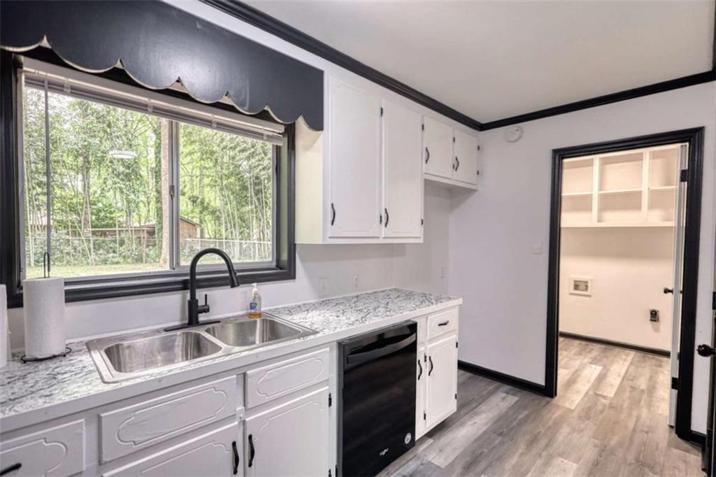 555 Joy Street Jackson, GA 30233 - Photo 26 of 56 a kitchen with granite countertop a sink cabinets stainless steel appliances and a large window