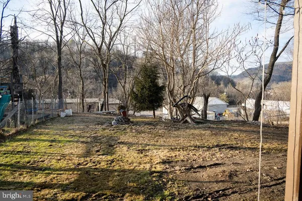 a view of a house with large trees and a yard