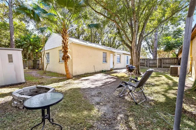 a view of a house with backyard and tree