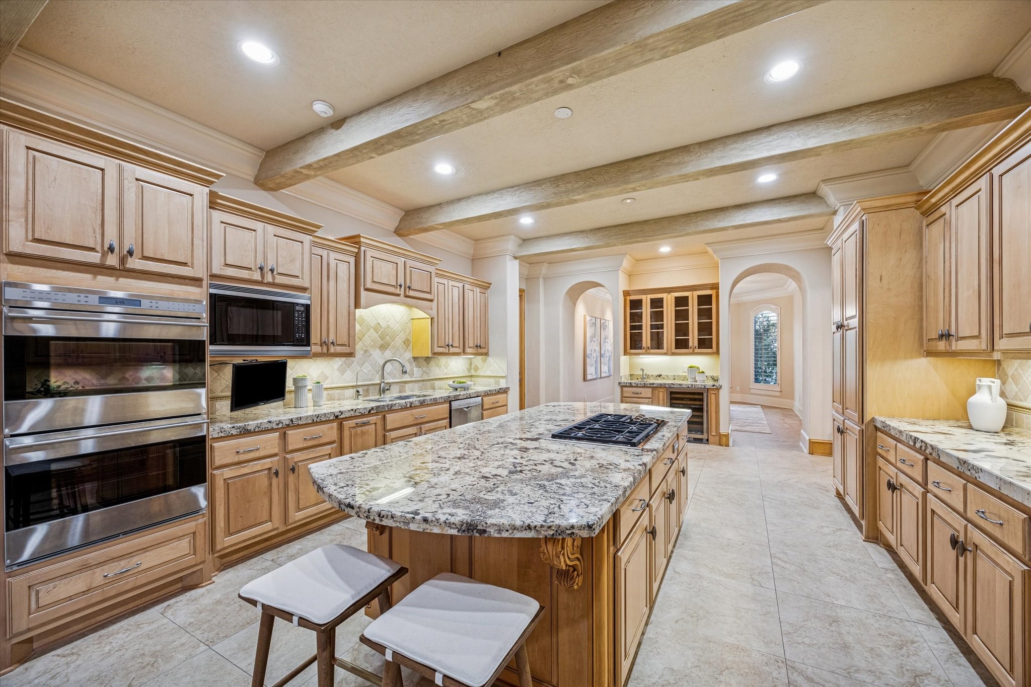 13907 Slate Creek Lane Houston, TX 77077 - Photo 11 of 29 a kitchen with kitchen island granite countertop wooden cabinets and stainless steel appliances