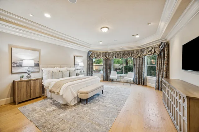 a spacious bedroom with a large bed and a flat screen tv