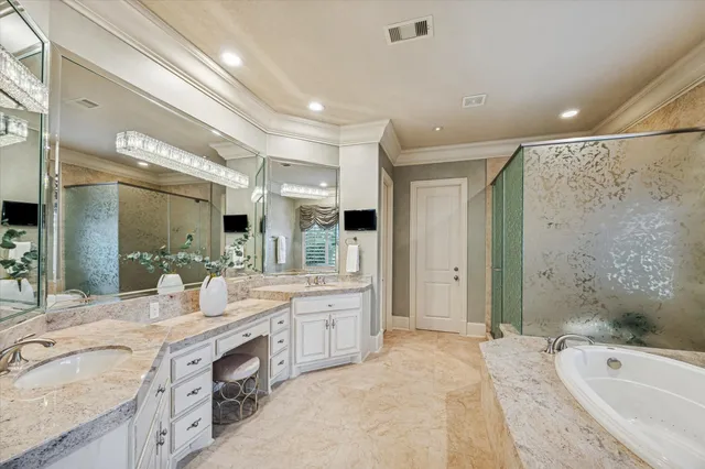 a spacious bathroom with a granite countertop double vanity sink a mirror and a bathtub