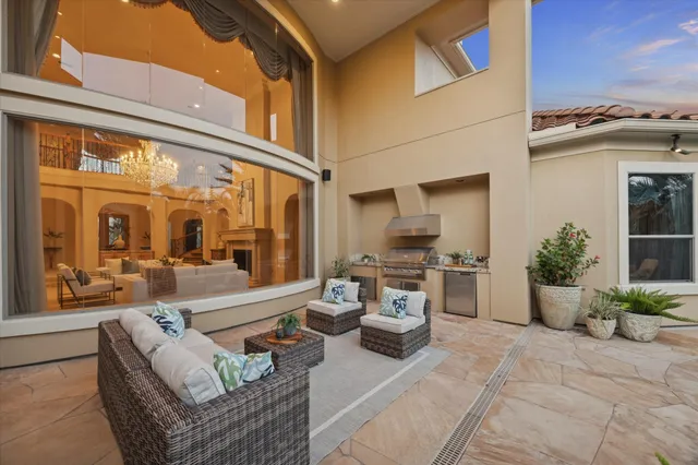 a backyard of a house with barbeque oven table and chairs