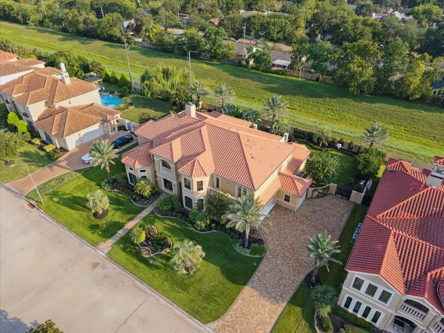 an aerial view of residential houses with outdoor space and lake view