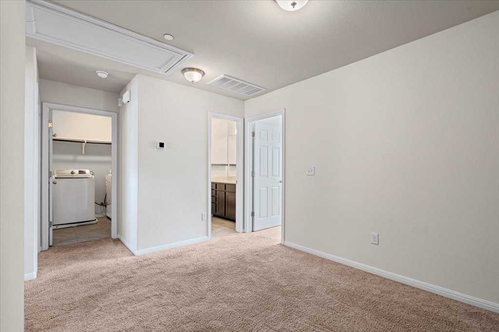 1609 Catalan Road, Unit 1802 Austin, TX 78748 - Photo 15 of 25 Unfurnished bedroom with washer / dryer, attic access, light colored carpet, and connected bathroom